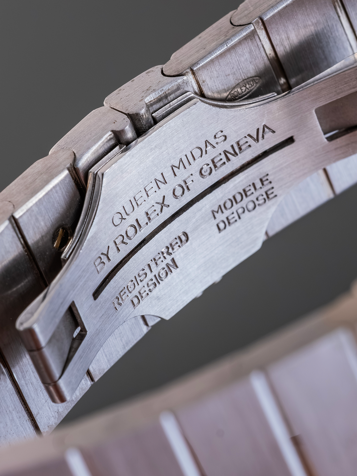 Close-up of a watch band with engraved text on a dark background
