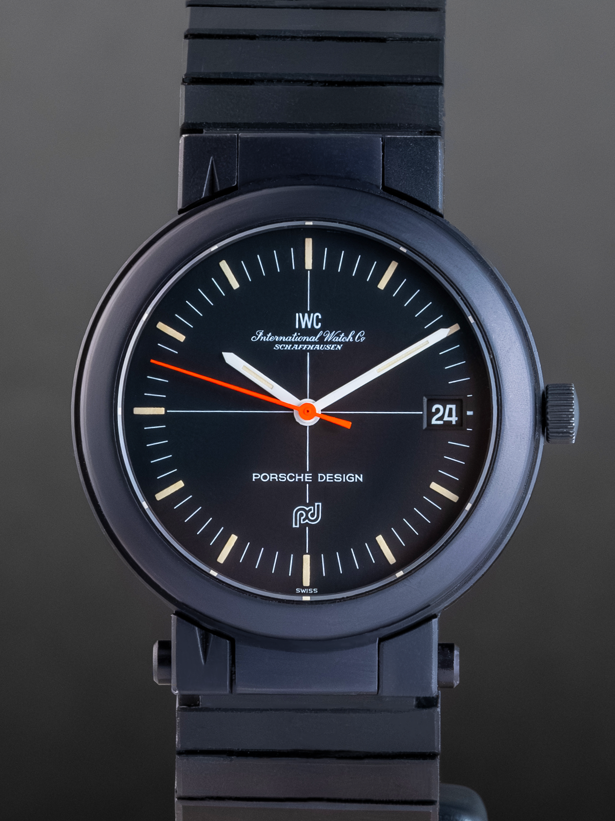 Black watch with Porsche Design and IWC branding on a dark background
