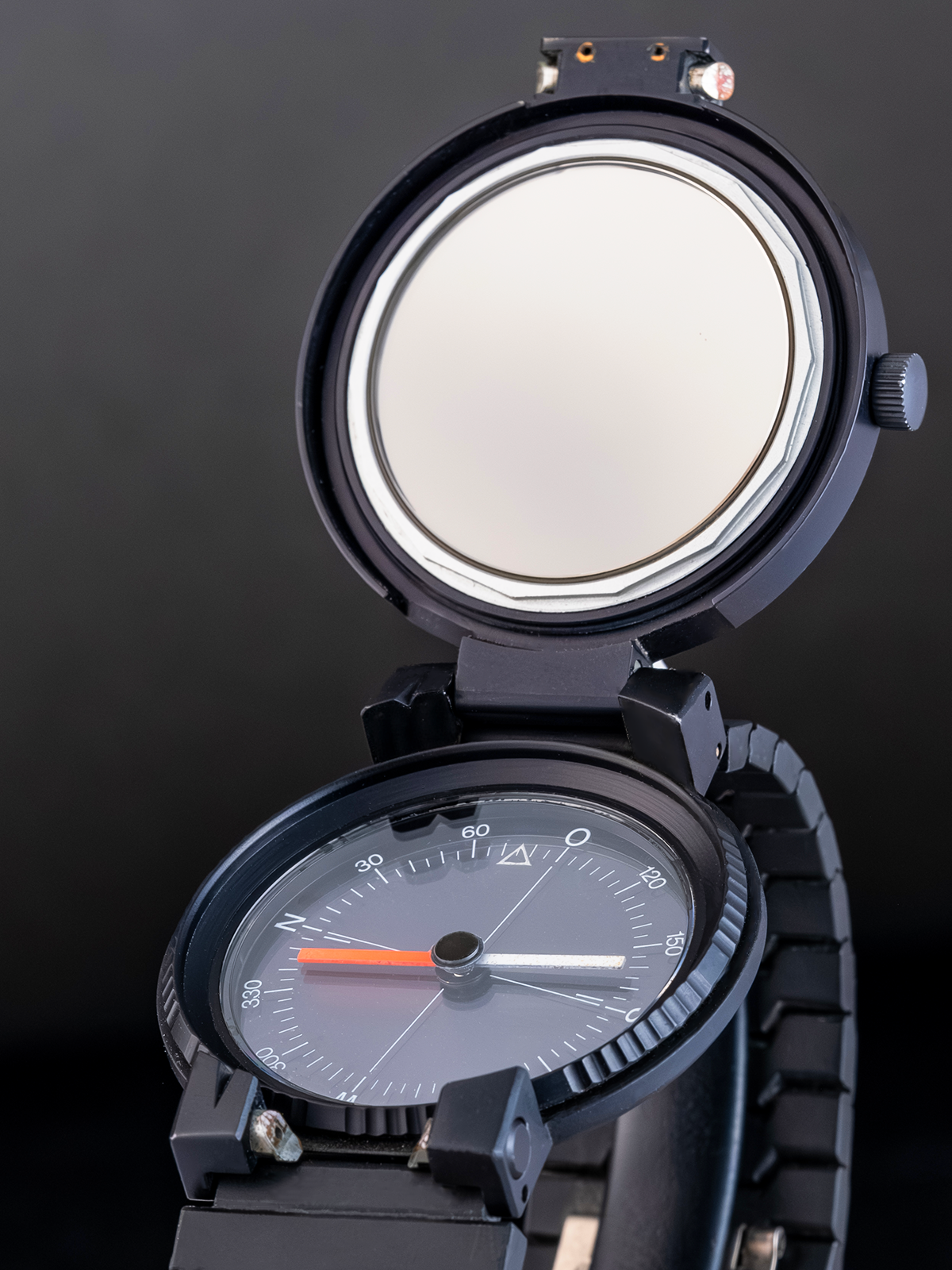 Black wristwatch with open face on a dark background