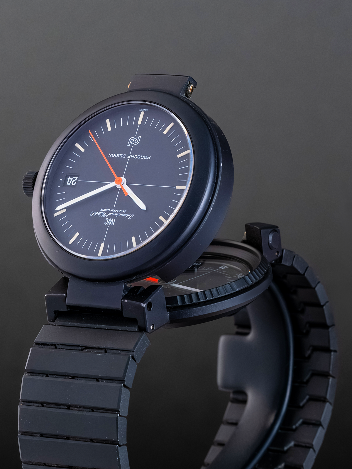 Black wristwatch with a dark strap on a gray background
