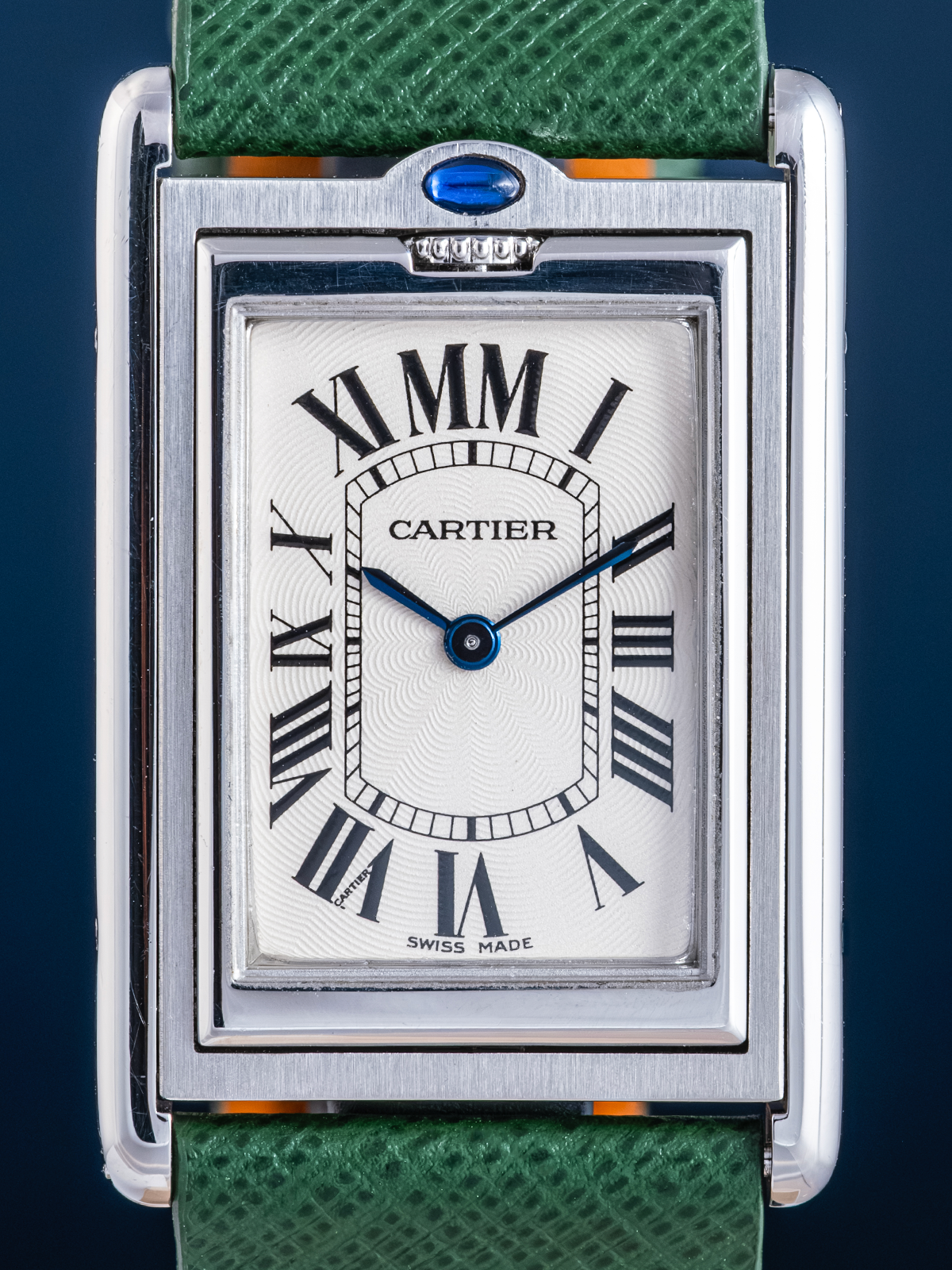 Cartier watch with green strap on a dark background