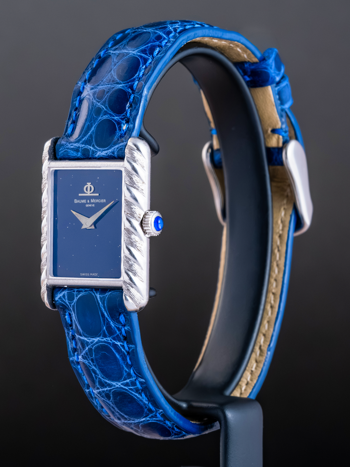 Watch with blue strap and silver case on a dark background