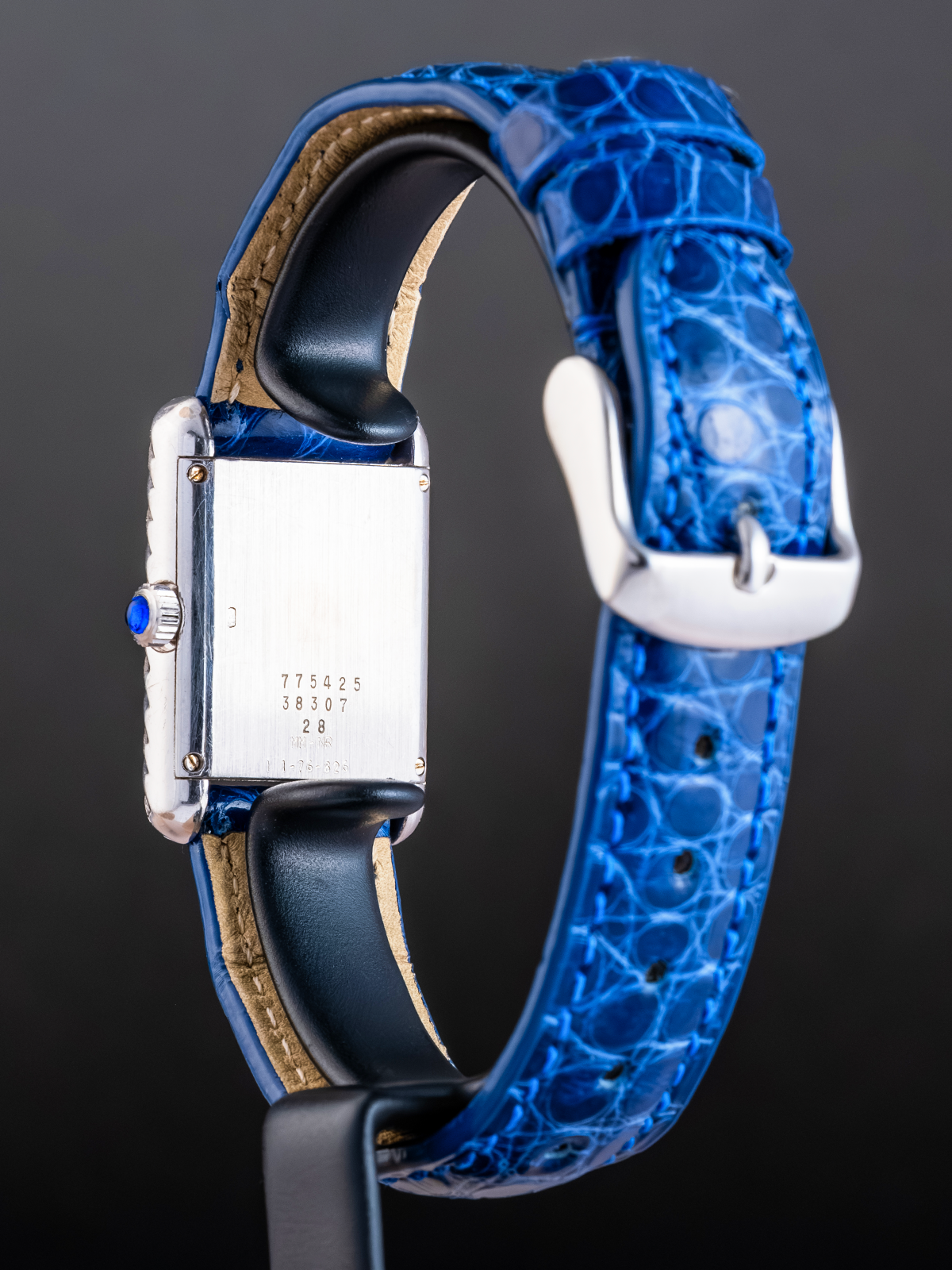 Wristwatch with a blue textured strap on a dark background