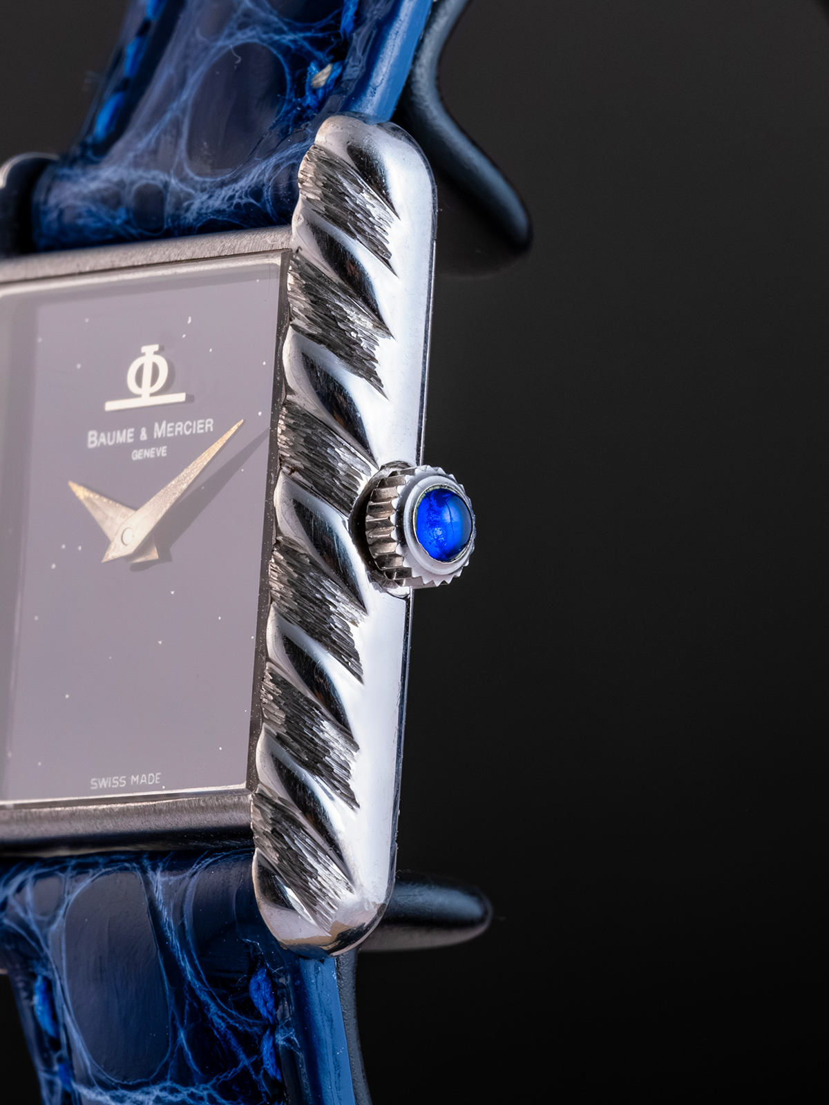 Watch with a blue gemstone on a dark background