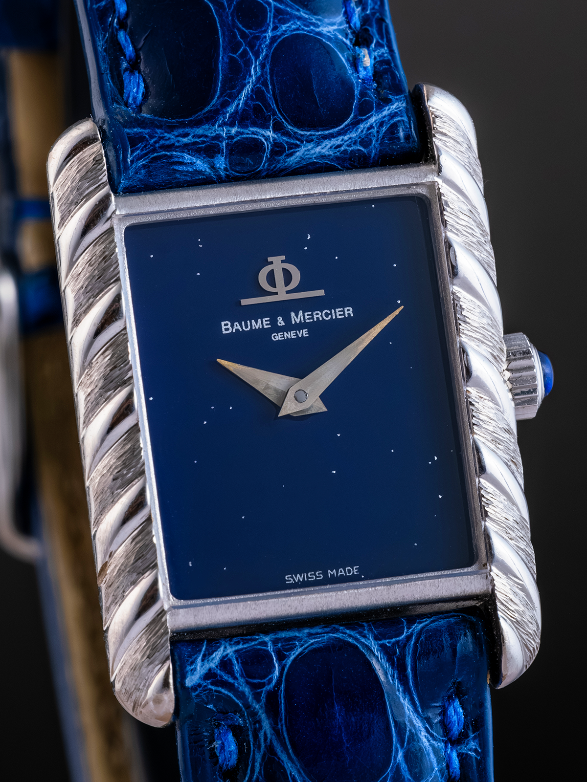 Baume & Mercier watch with blue strap and face on a dark background