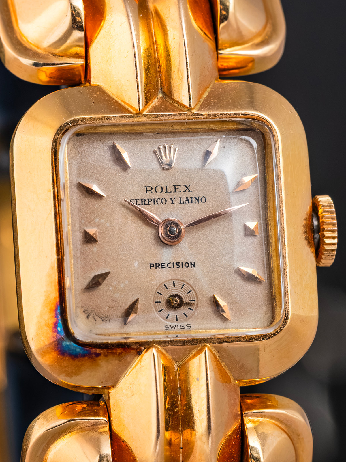 Gold Rolex watch with a detailed face on a dark background