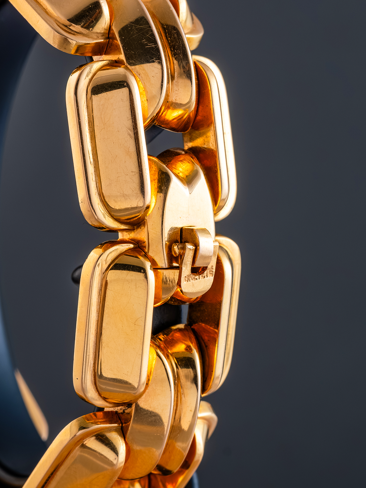 Close-up of a gold chain bracelet on a dark background