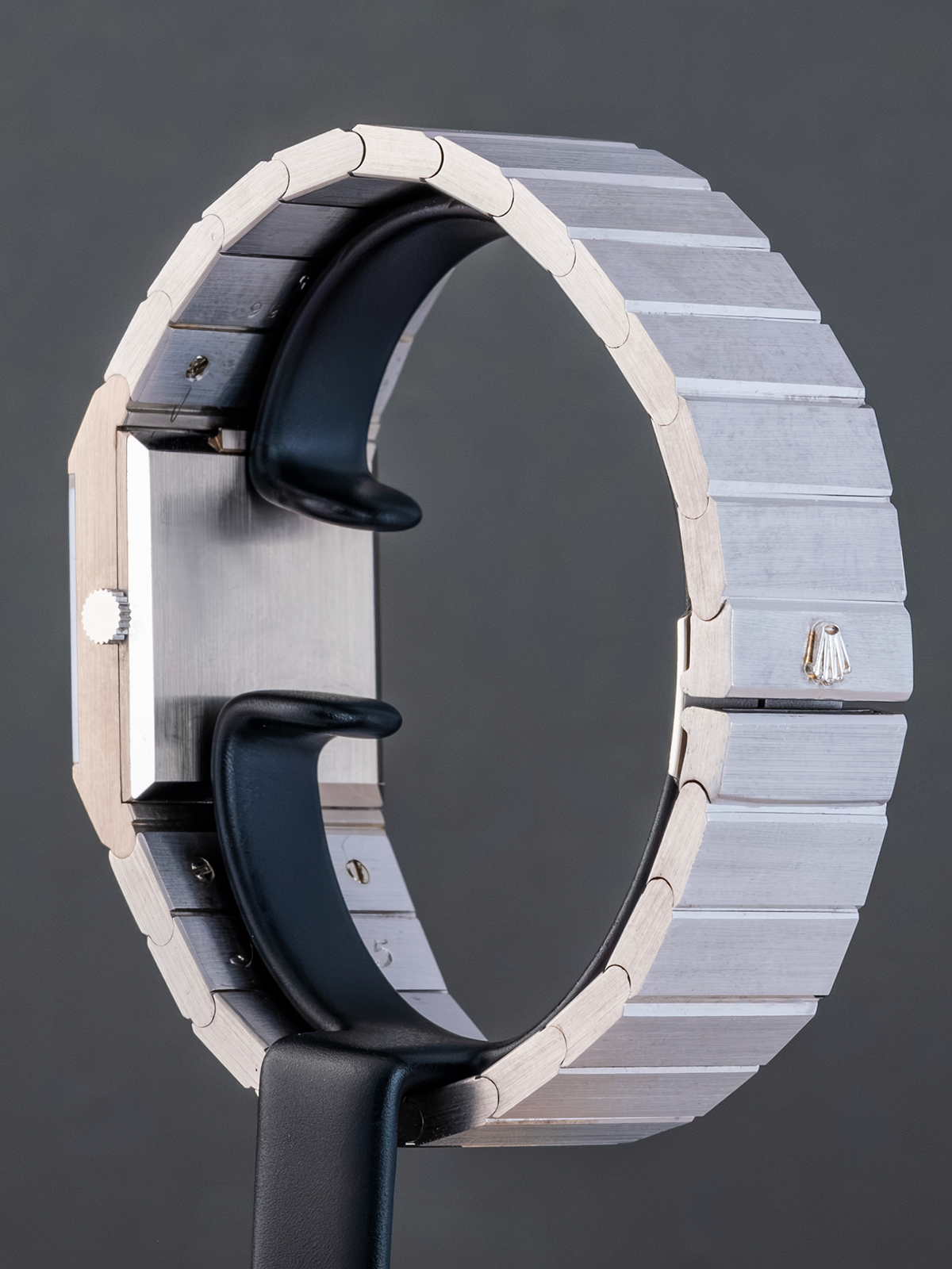 Close-up of a modern watch with a metallic band and black strap on a dark background