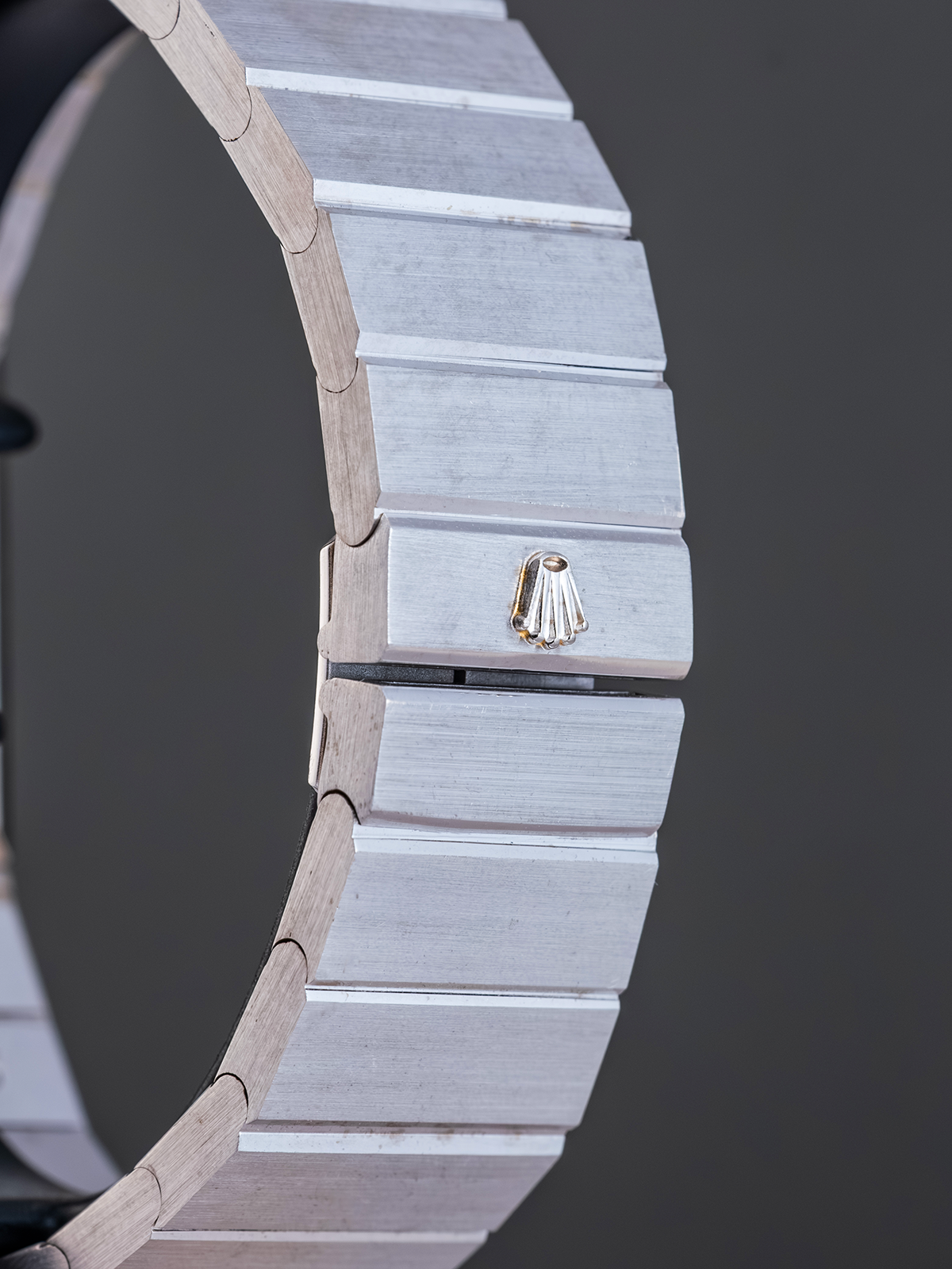 Close-up of a watch with a detailed metal band on a dark background