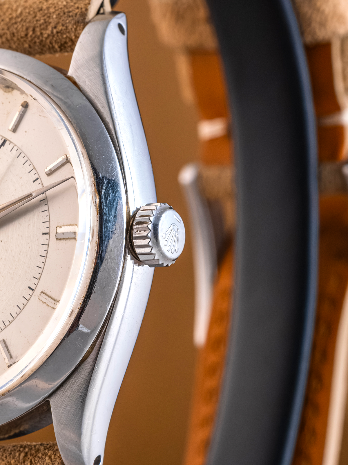 Close-up of a watch with a detailed face and metallic band on a wooden surface.