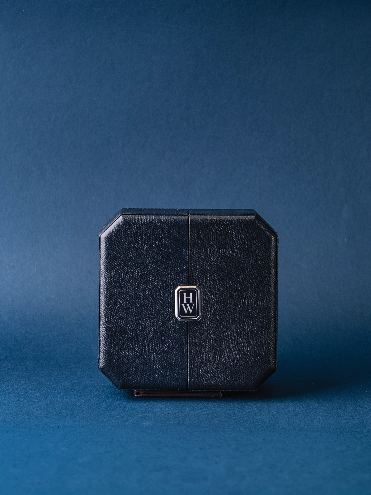 Black rectangular product with a logo on a blue background