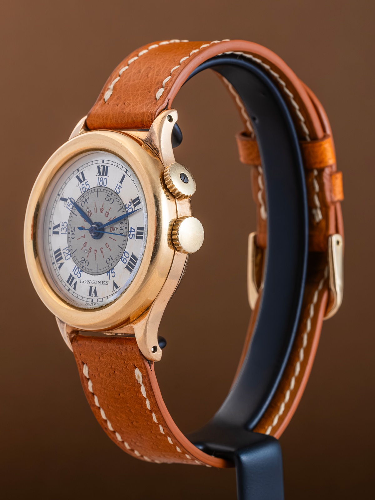 Luxury watch with brown leather strap on a brown background