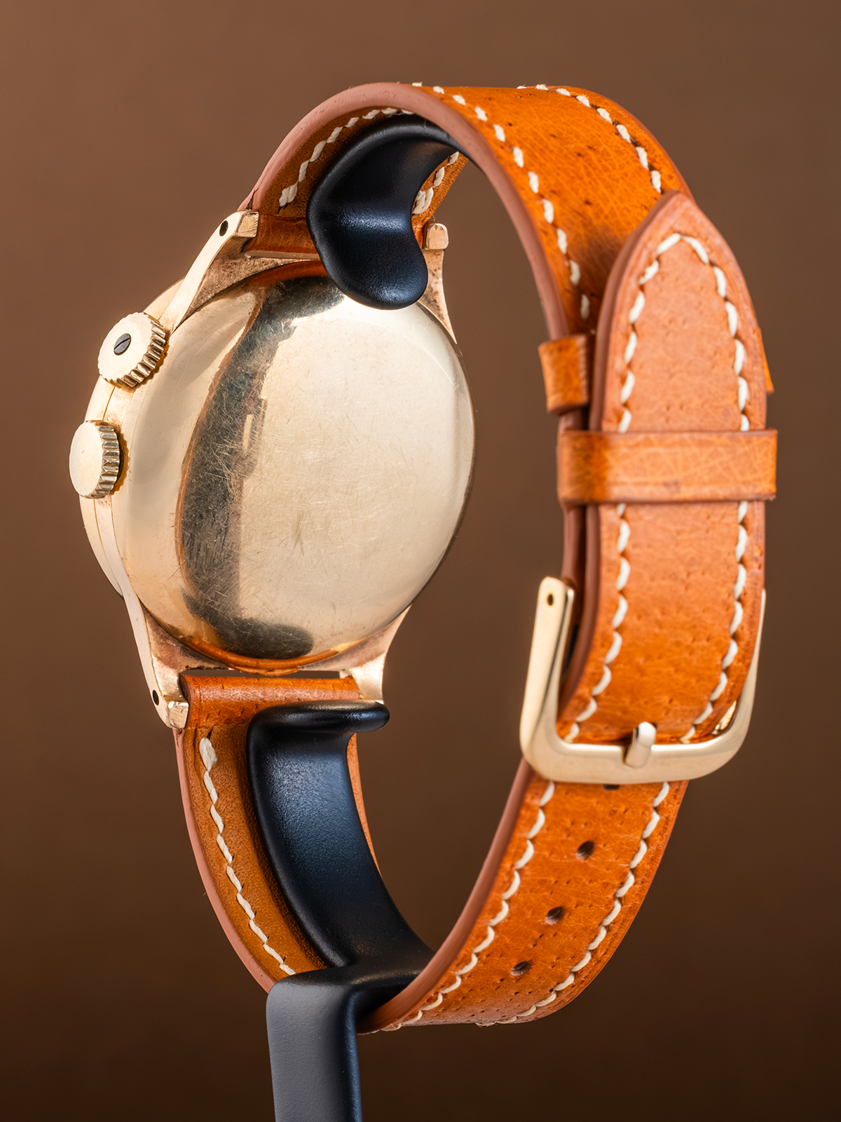 Watch with a brown leather strap on a brown background