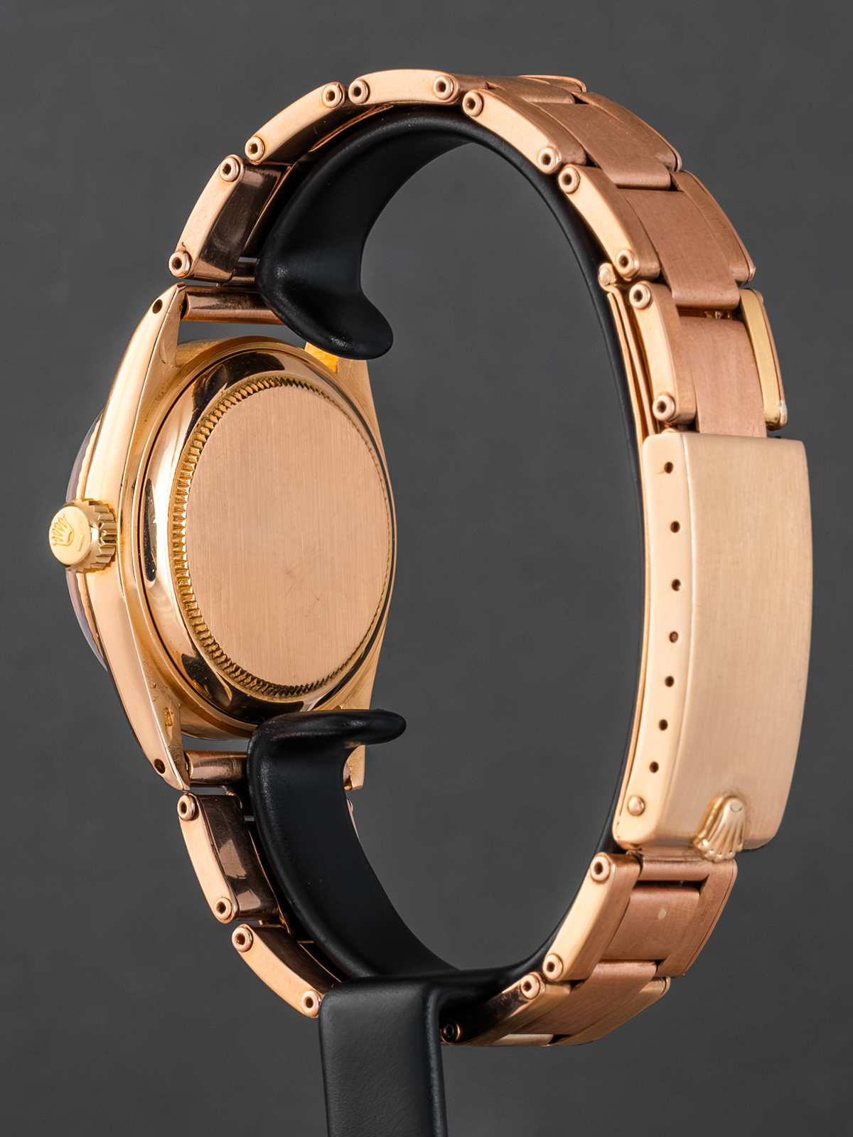Rose gold watch with black strap on a dark background