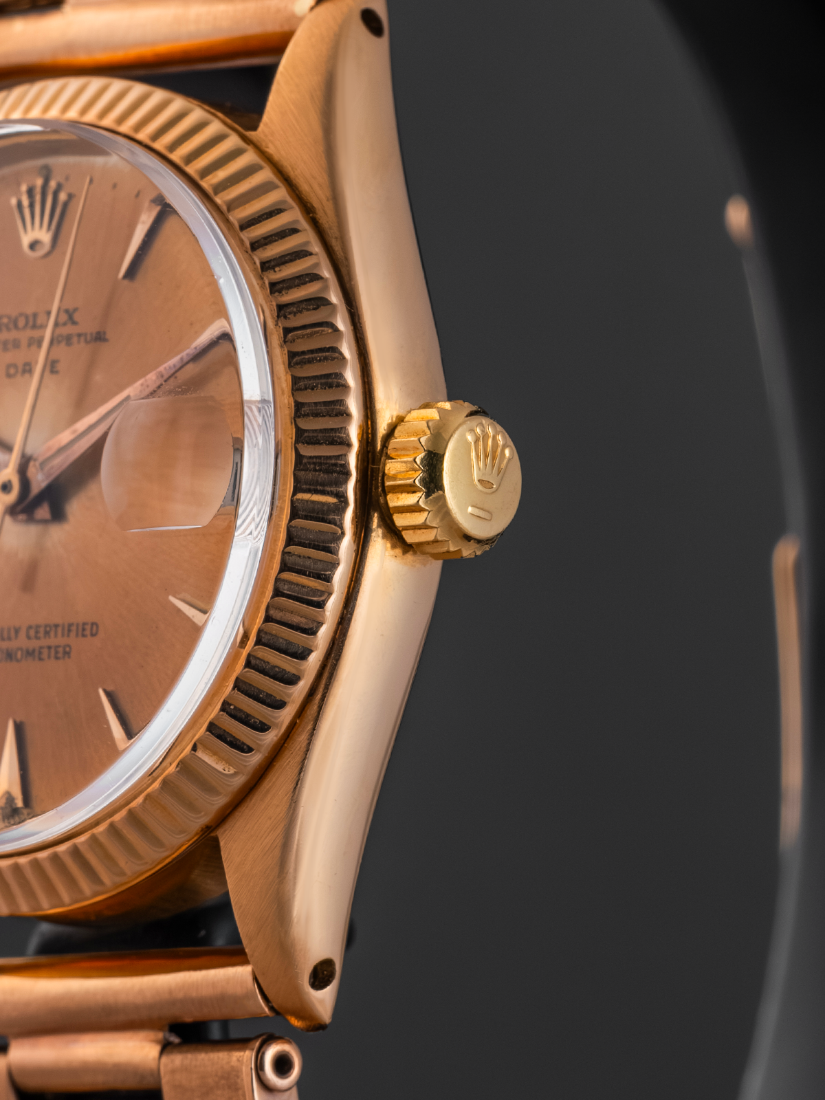 Close-up of a gold wristwatch with a dark background