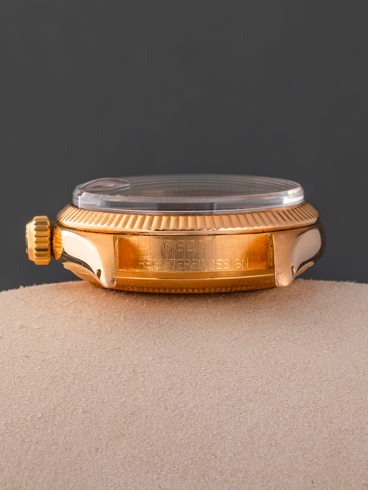 Gold watch case on a gray background