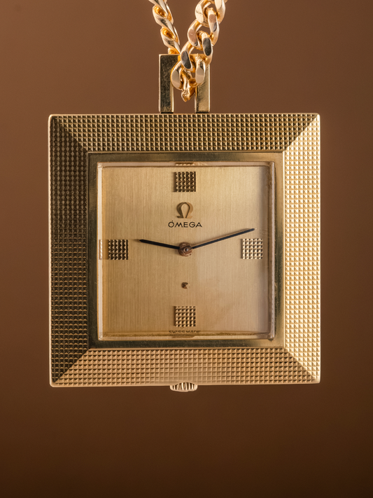 Gold Omega watch pendant on a brown background