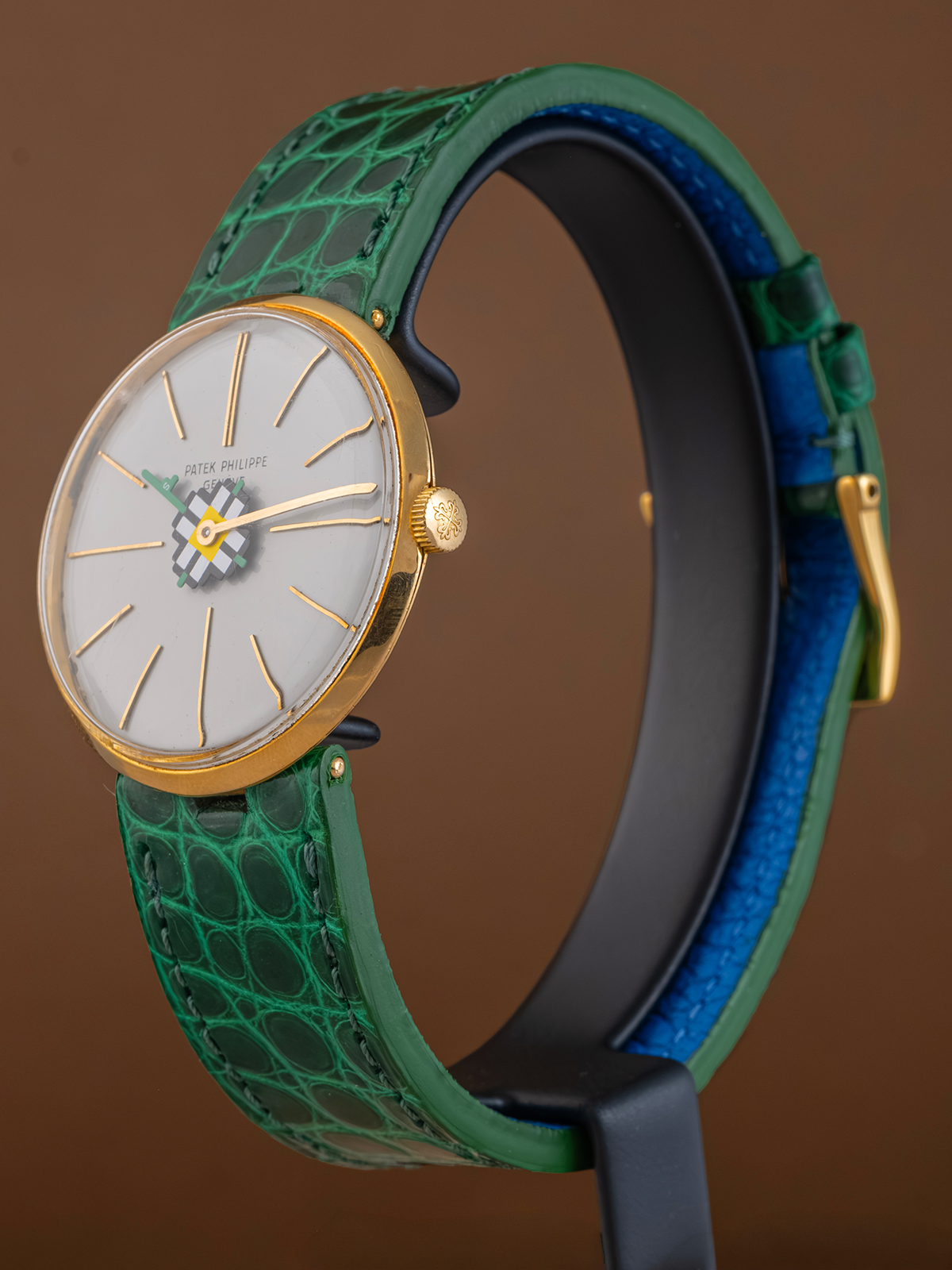 Watch with green strap and gold accents on a brown background