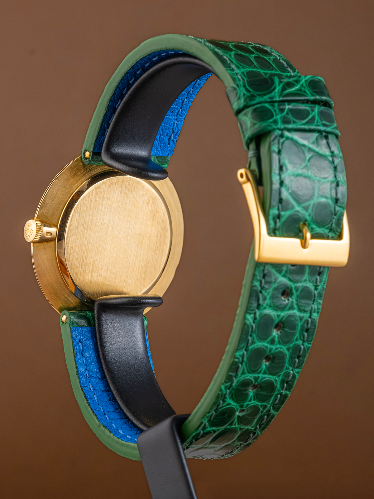 Watch with a green and blue strap on a brown background