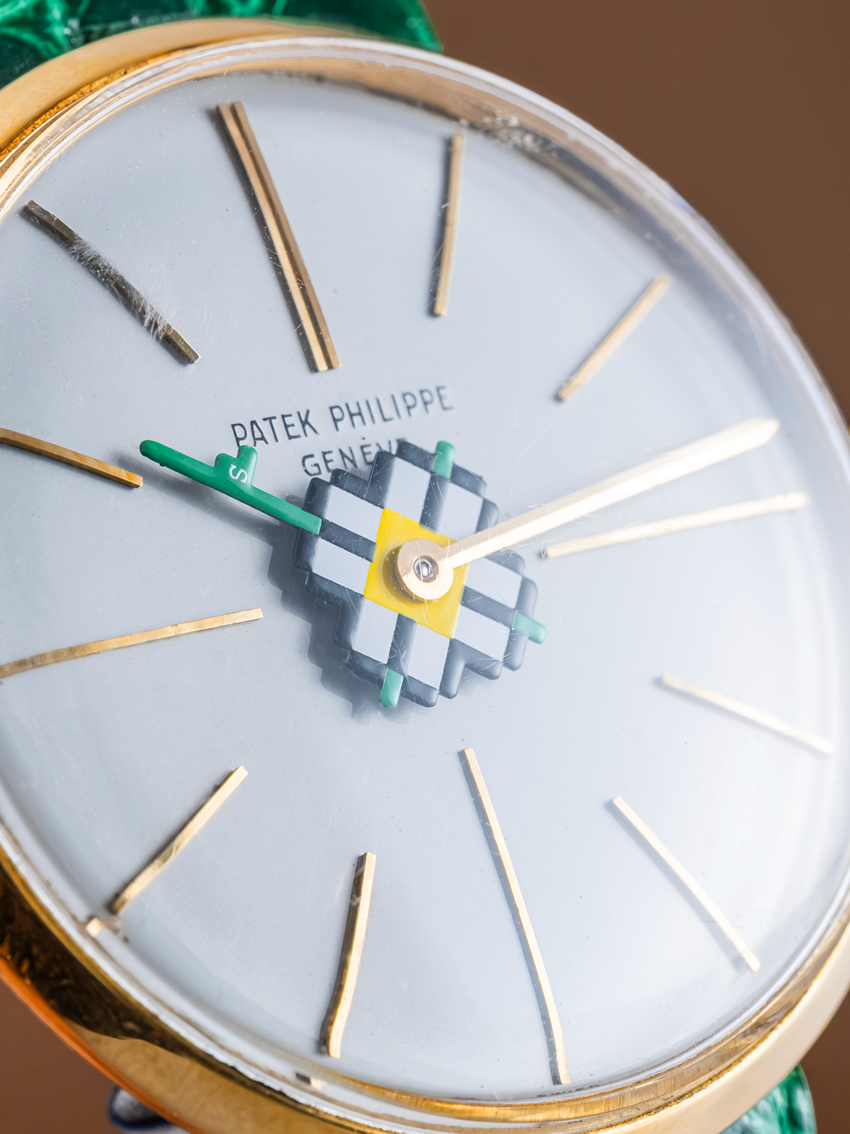 Close-up of a Patek Philippe watch face with gold and white design.