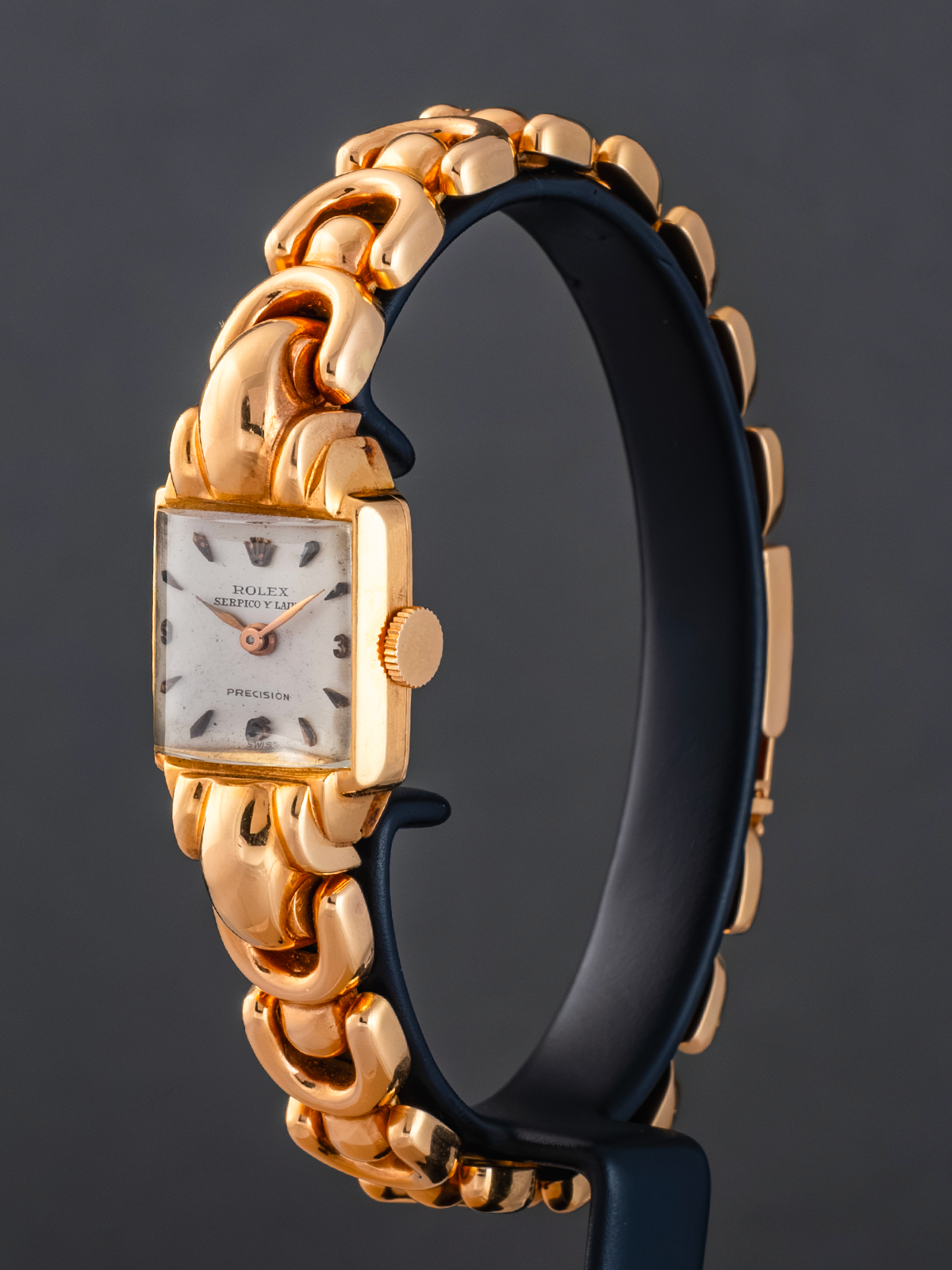 Gold and black watch with a dark background