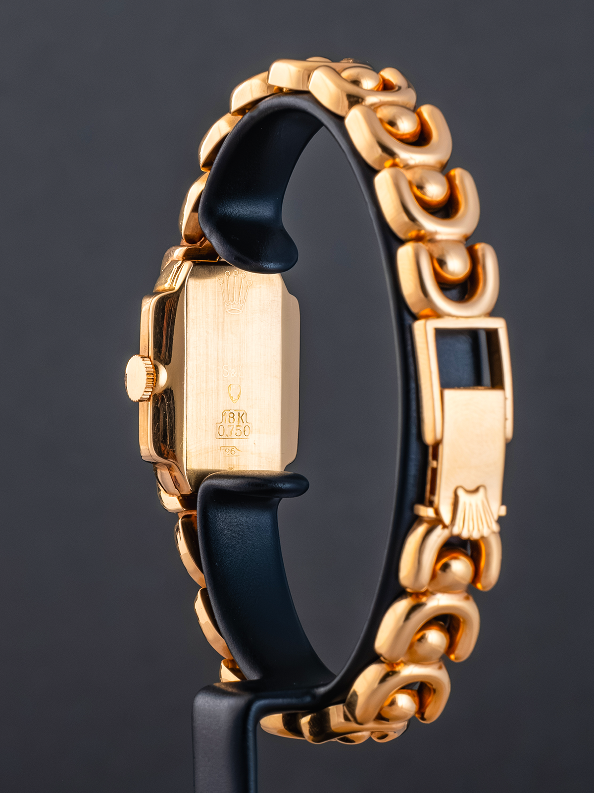 Gold and black smartwatch on a dark background