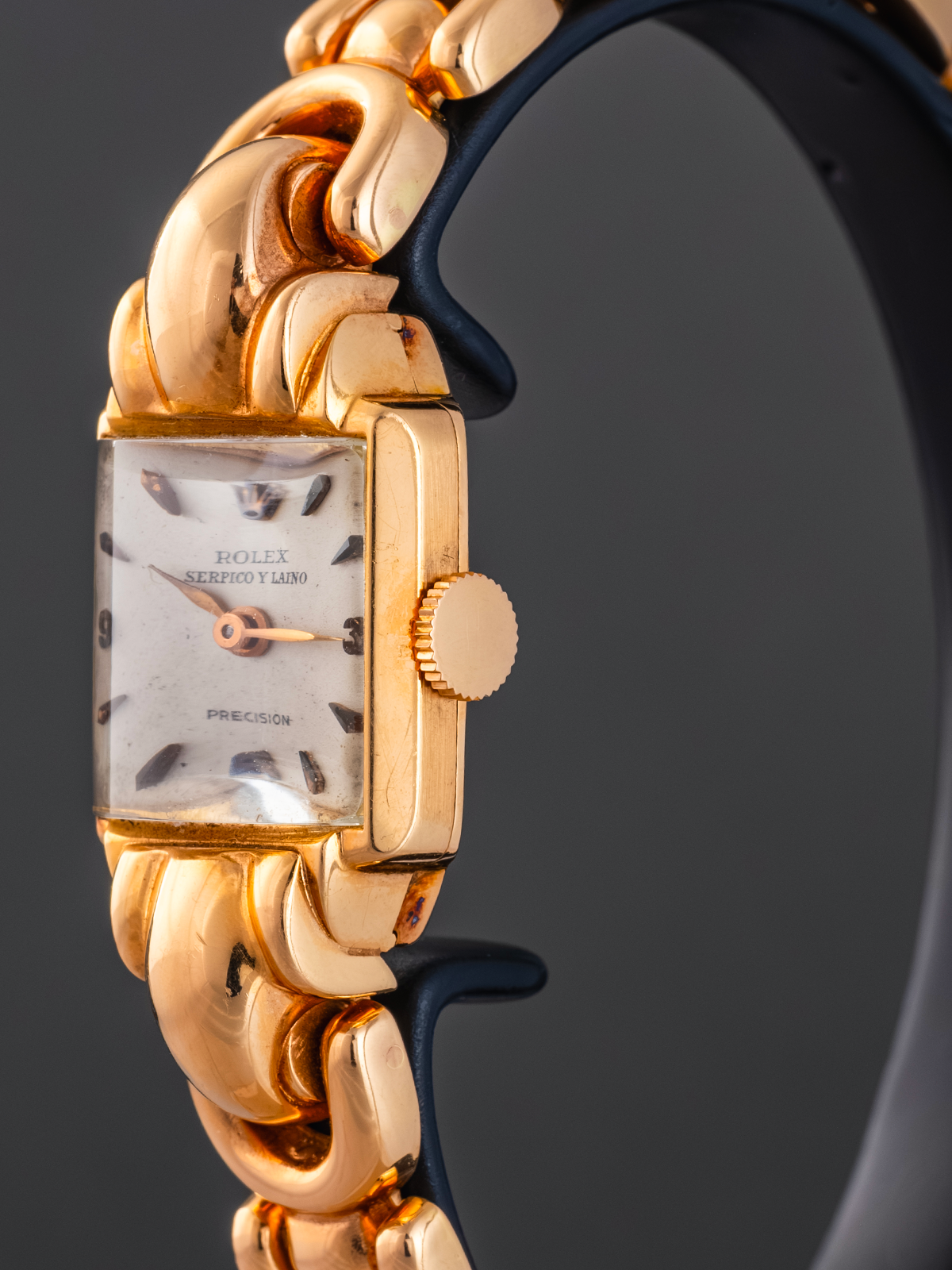 Gold wristwatch with a dark strap on a black background