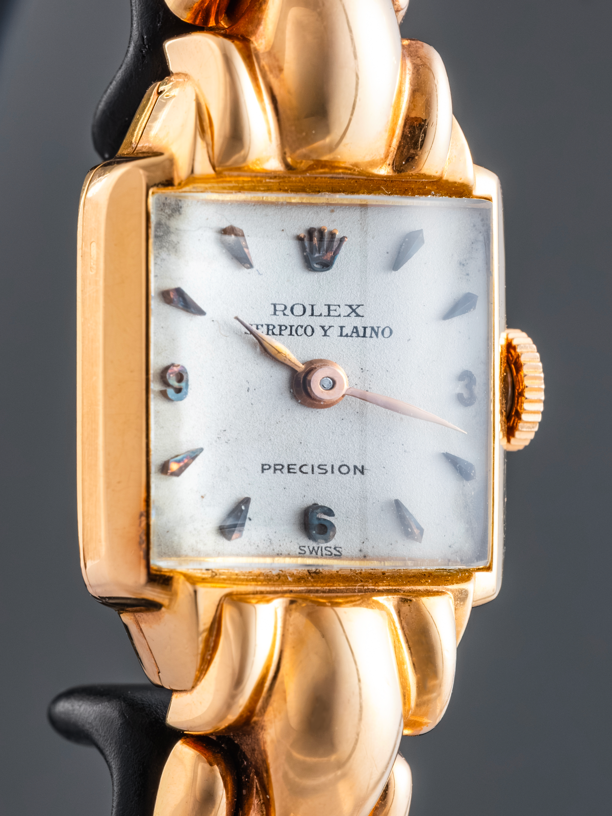 Gold Rolex watch with a detailed face on a dark background