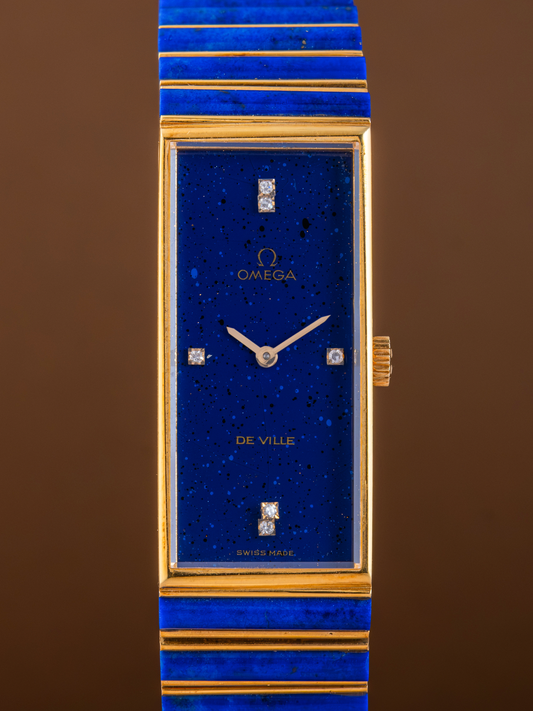 Luxury watch with blue face and gold accents on a brown background