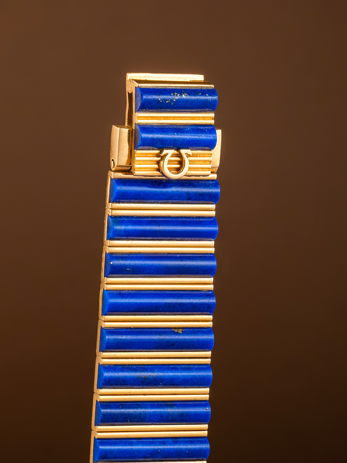 Gold and blue bracelet on a brown background