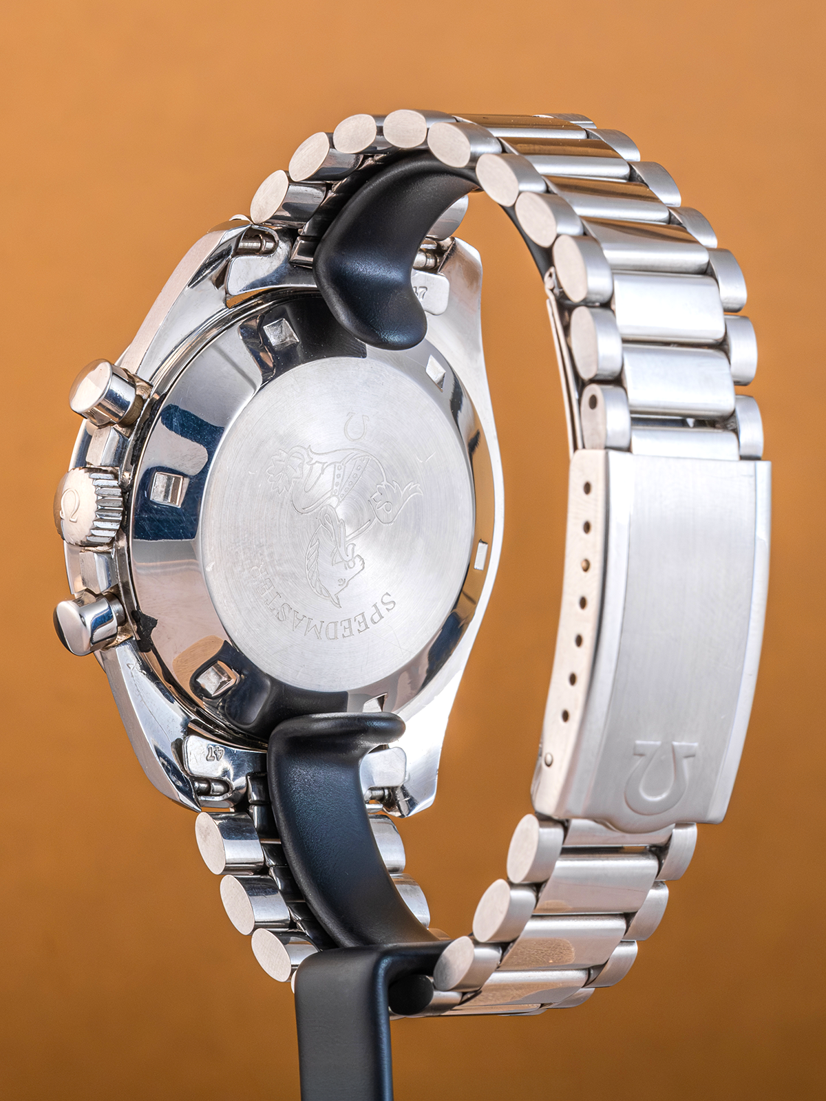 Close-up of a silver watch with a brown background