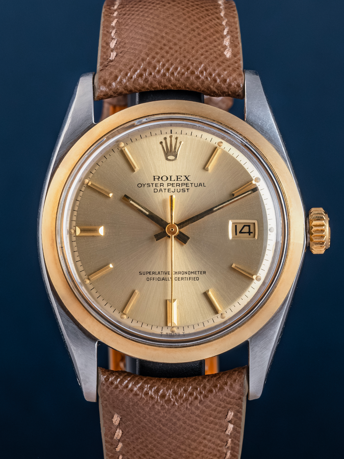 Rolex watch with brown leather strap on a dark blue background
