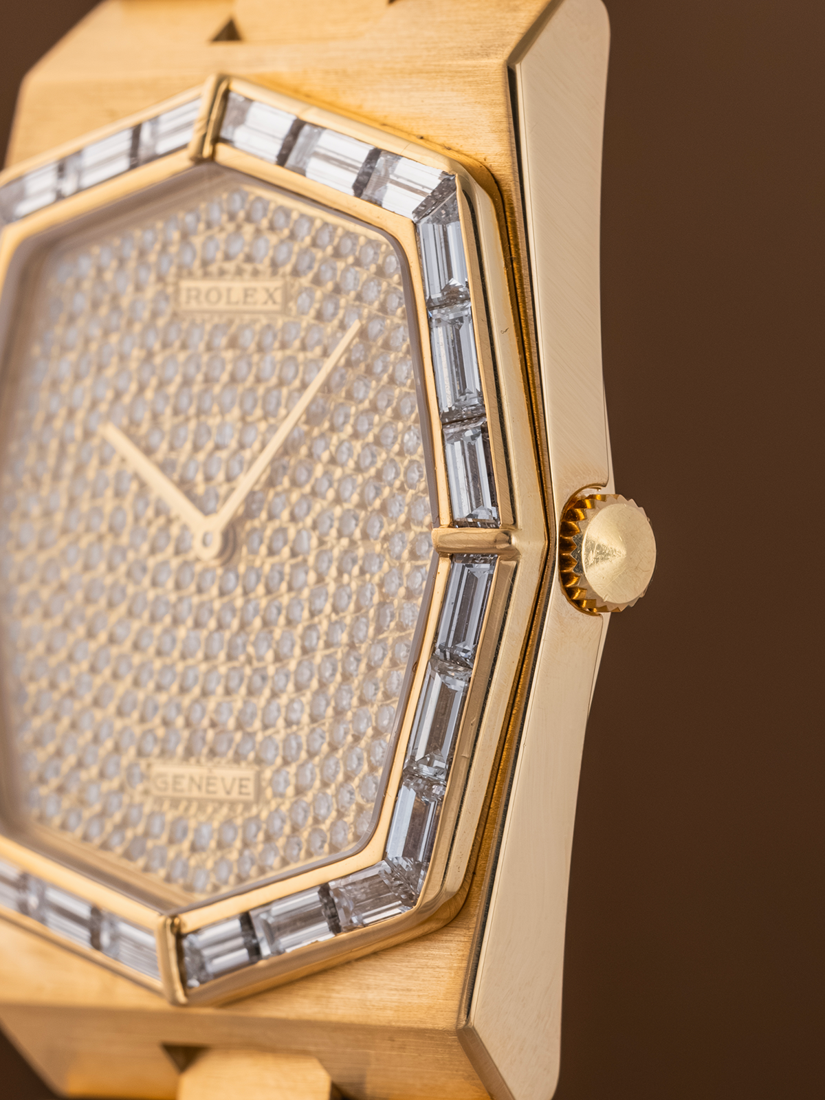 Gold Rolex watch with diamond-studded face on a brown background