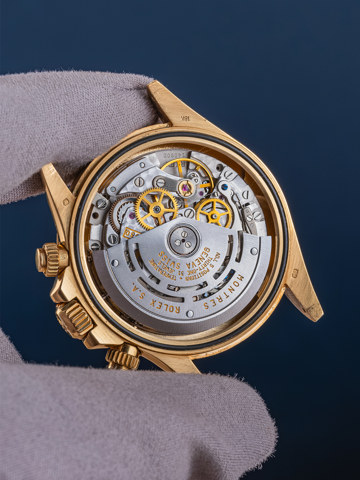 Close-up of a gold watch mechanism on a dark background