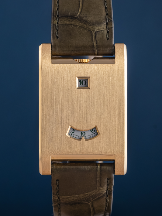 Gold watch case with brown leather strap on a blue background