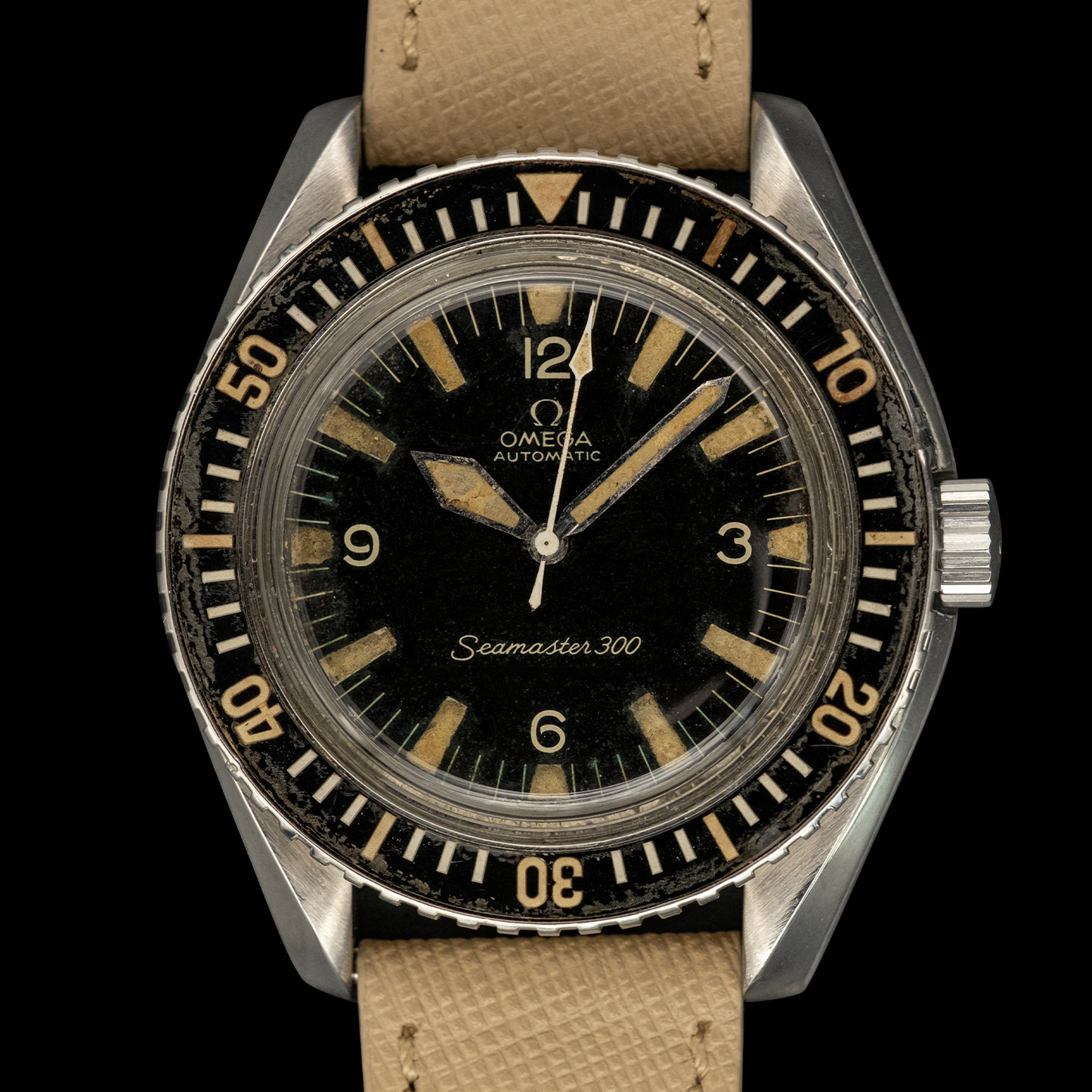 Vintage Omega Seamaster 300 watch with black dial and brown leather strap on a black background