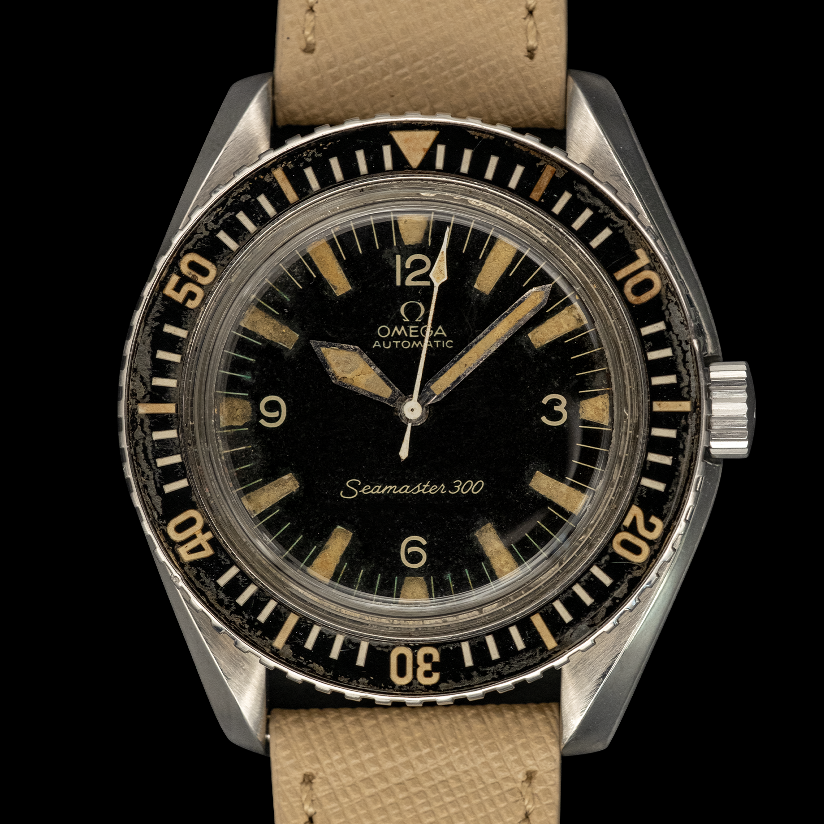Vintage Omega Seamaster 300 watch with black dial and brown leather strap on a black background