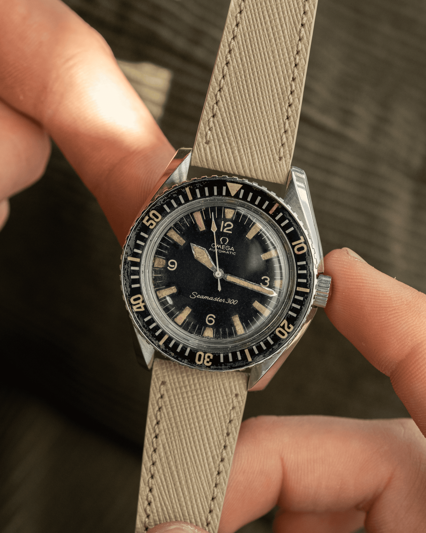 Vintage watch with a beige strap held by a person